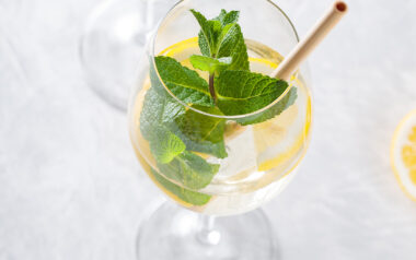 Citrusos-mentás spritz borospohárban, jéggel és bambusz szívószállal