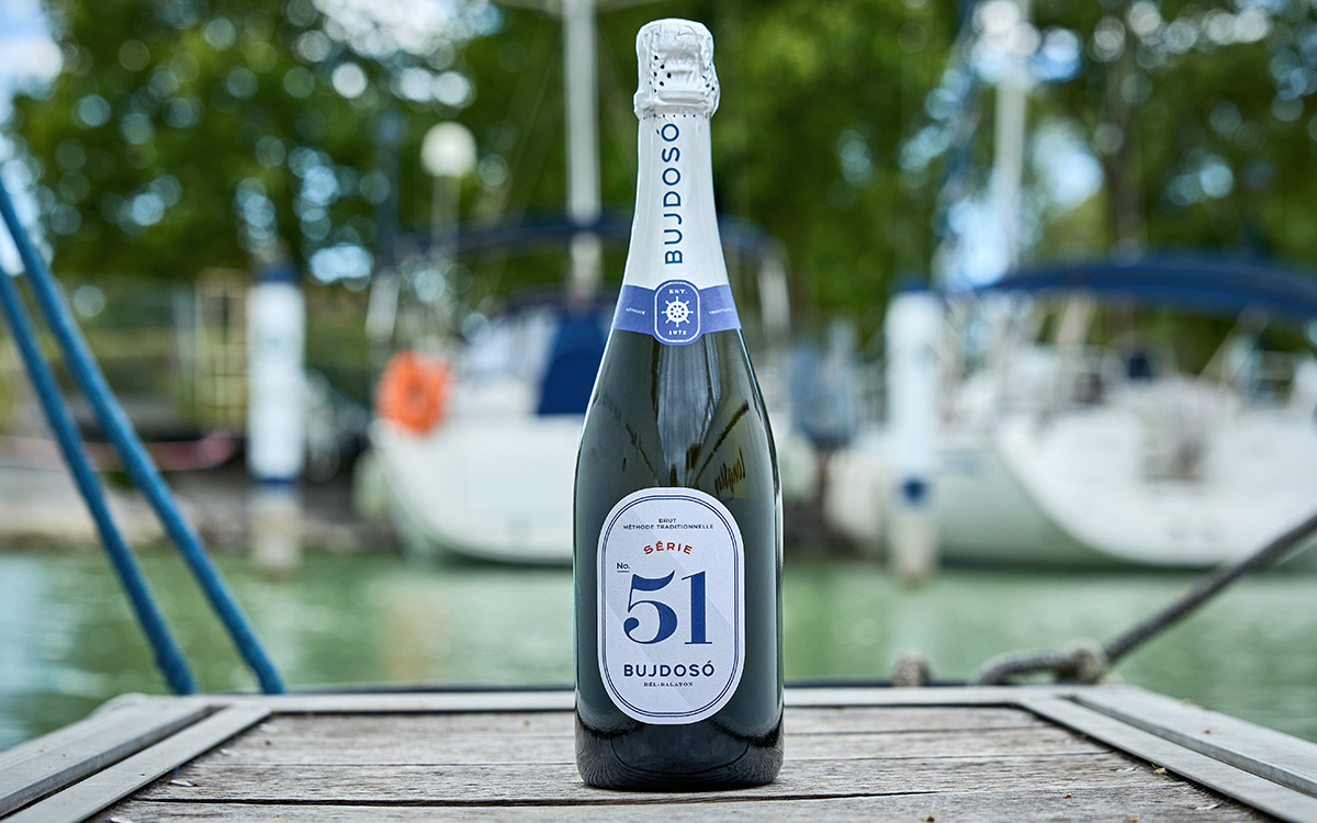 Bujdosó Série 51 Brut pezsgő palackja egy balatoni kikötőben
